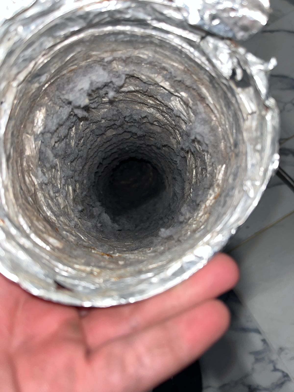 Dryer vent flex hose interior completely caked with heavy lint accumulation before SunDuct cleaning