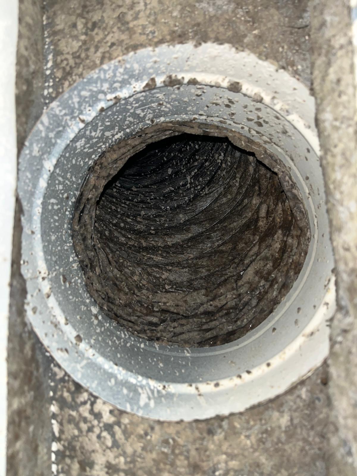 Round dryer vent at roof cap completely blocked with compacted lint before SunDuct cleaning