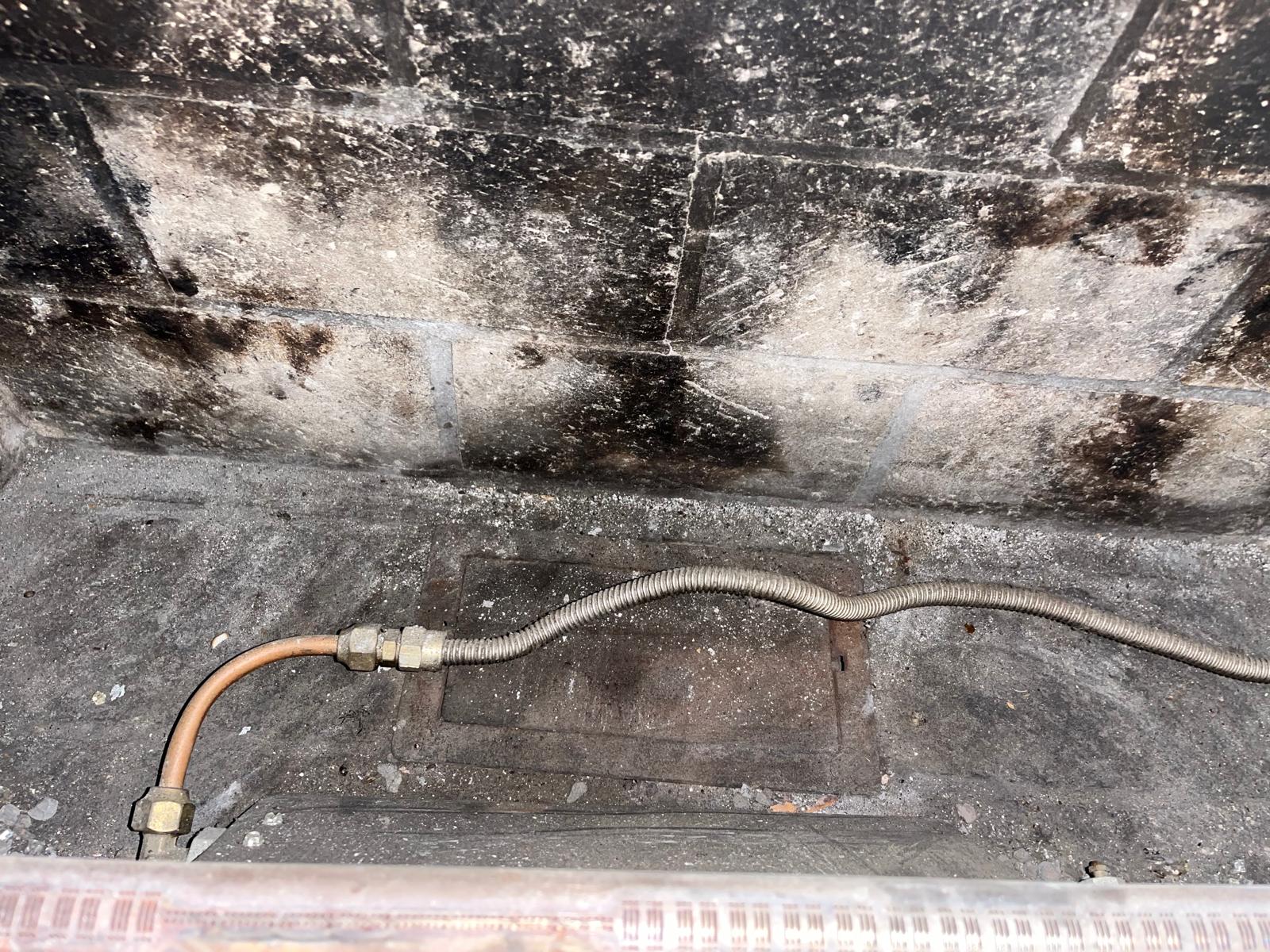Mold and water damage on concrete near HVAC equipment requiring duct sanitizing service
