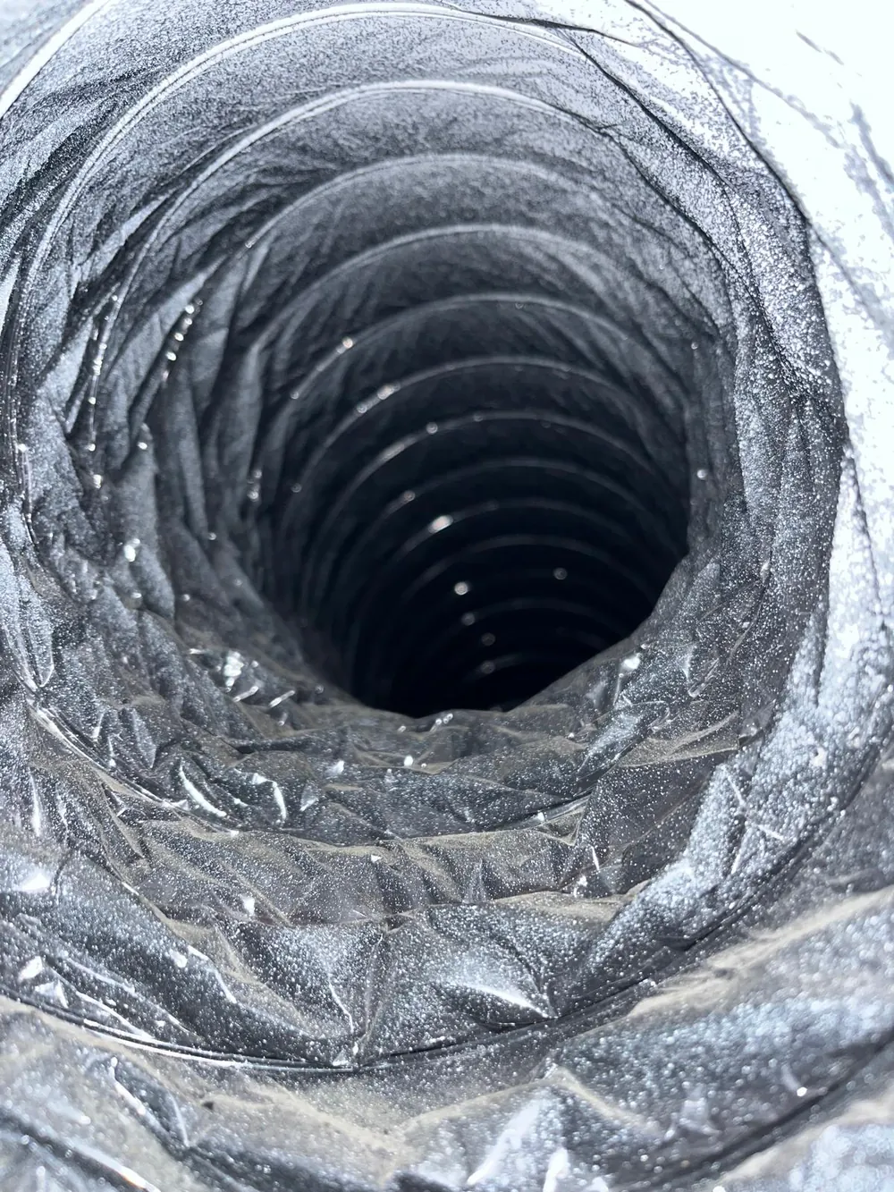 Inside a flexible dryer duct coated with lint before professional dryer vent cleaning in Florida