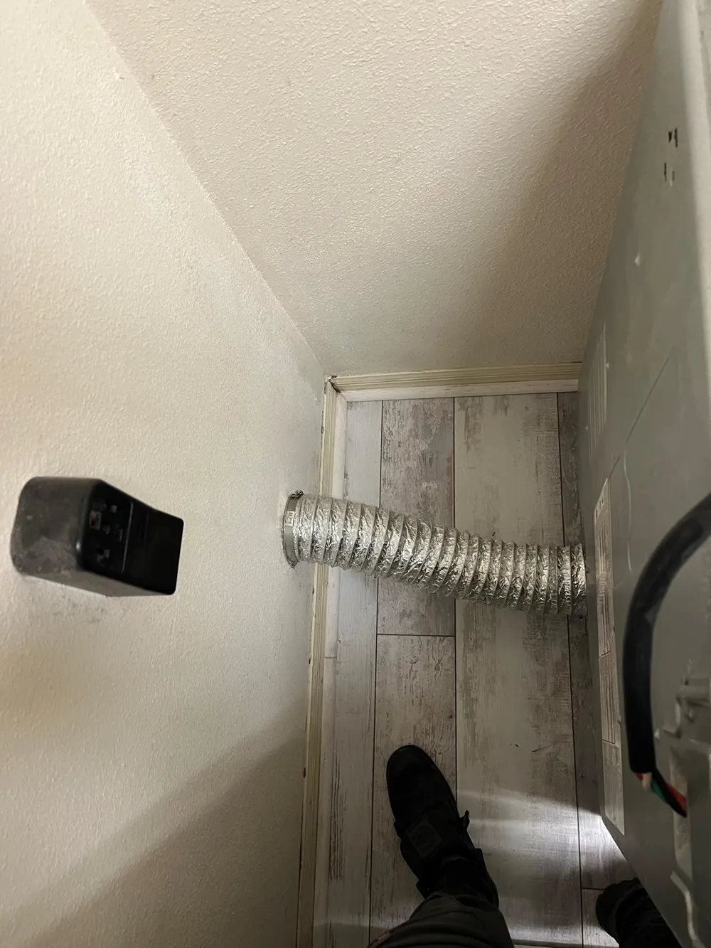 New aluminum transition duct installed behind a dryer after dryer vent cleaning service on the Treasure Coast